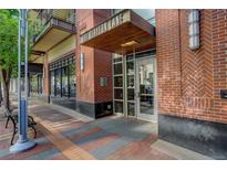 The residential building features brick accents and inviting entrance with covered doorway and professional landscaping at 191 Clayton Ln # 402, Denver, CO 80206