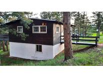 Exterior of the home with a dark siding, featuring a ramp leading to the front door, with trees surrounding at 7105 Flagstaff Rd, Boulder, CO 80302