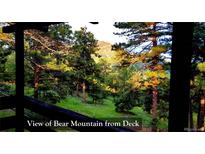 Beautiful view of Bear Mountain from the deck, surrounded by lush greenery and tall trees at 7105 Flagstaff Rd, Boulder, CO 80302