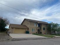 Two-story home featuring a spacious two-car garage and a well-manicured lawn at 1123 S Quince Way, Denver, CO 80231