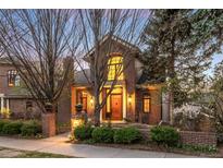 Charming brick home featuring a peaked roof, large windows, and inviting landscaped front yard at 465 Monroe St, Denver, CO 80206