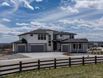 Beautiful modern home featuring stone accents, large windows, and a spacious three car driveway at 3226 Wingspan Pt, Castle Rock, CO 80108