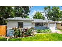 Charming ranch style home featuring a manicured lawn and flower beds at 3317 W Belmont Ave, Littleton, CO 80123