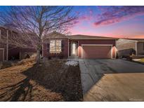 Ranch style home with a two-car garage and landscaped yard at 851 Lonewolf Cir, Lochbuie, CO 80603