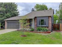 Charming single-Gathering home with a well-manicured lawn, brick accents and an attached garage at 17605 Ponderosa Ave, Parker, CO 80134