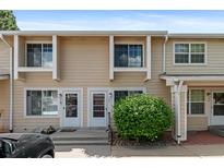 Tan two-story townhouse with well-manicured front yard and partial car view at 8979 Field St # 27, Westminster, CO 80021
