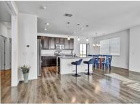 Open kitchen featuring dark cabinetry, granite countertops, stainless appliances, and a breakfast bar with pendant lighting at 4569 Copeland Loop # 203, Highlands Ranch, CO 80126