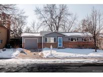 Charming single Gathering home with brick accents, an attached garage, and mature trees in the winter at 18908 E Napa Dr, Aurora, CO 80013