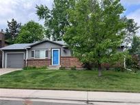 Charming single-story home with a blue front door, brick accents, and well-manicured lawn at 18908 E Napa Dr, Aurora, CO 80013