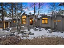 Stunning two-story home with a gray exterior, snow-covered landscaping, and a large window at 29432 Camelback Ln, Evergreen, CO 80439