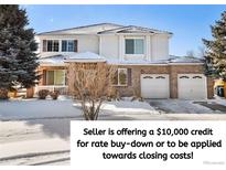 Charming two-story home with a brick and siding exterior, showcasing a well-maintained front yard in a snowy setting at 11821 Joplin Ct, Commerce City, CO 80022