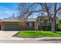 Charming home features brick and siding exterior, large driveway, and grassy front yard at 4581 S Garrison St, Littleton, CO 80123