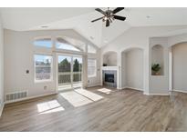 Spacious living room features vaulted ceilings, fireplace, and large windows with sliding door to the outdoor deck at 1574 Olympia Cir # 305, Castle Rock, CO 80104