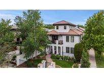 Stunning two-story home with a red tile roof, arched entry, balcony, and beautifully landscaped front yard at 579 Madison St, Denver, CO 80206