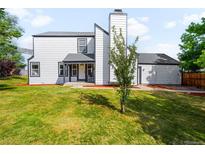 Charming two-story home with green lawn and attractive curb appeal on a sunny day at 9654 W Elmhurst Pl, Littleton, CO 80128
