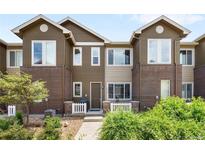 Attractive two-story townhome with brick accents, white picket fence, and manicured landscaping at 15546 W 64Th Loop # C, Arvada, CO 80007
