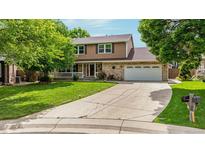 Charming two-story home featuring a well-manicured lawn, mature trees, and a long driveway at 12414 Clayton Way, Thornton, CO 80241