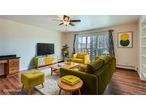 Bright living room with stylish furniture, a ceiling fan, and large windows showcasing the outdoor view at 9335 E Center Ave # 7B, Denver, CO 80247