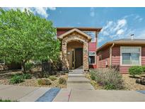 Inviting front entrance with a stone archway and well-maintained landscaping at 8552 Gold Peak Ln # F, Highlands Ranch, CO 80130