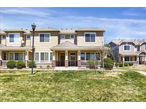 Charming tan two-story townhome with a covered front porch and well-maintained lawn at 16062 E Geddes Dr # 150, Aurora, CO 80016