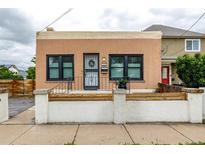 Charming home featuring a unique facade, black-trimmed windows, and decorative front yard fencing at 1803 E 36Th Ave, Denver, CO 80205