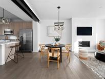Modern living room featuring a fireplace, dining area, and open concept kitchen with stainless steel appliances at 8711 E Hampden Ave # 20, Denver, CO 80231