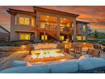 Inviting outdoor patio with a cozy fire pit and ample seating for relaxation and entertaining under a covered deck at 5388 Water Oak Cir, Castle Rock, CO 80108