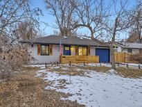 Charming single-story home with a blue door and matching garage, plus inviting wood accent features at 1140 S Elm St, Denver, CO 80246