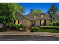 Charming brick home with dormer windows, mature trees, and inviting landscaping at 7190 S Poplar Ct, Centennial, CO 80112