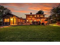 A spacious backyard features a pergola, outdoor seating, and a large lawn for relaxation and entertainment at 7678 Newman St, Arvada, CO 80005