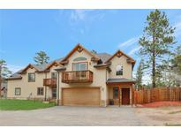 Charming two-story home featuring a balcony, attached garage, and beautifully designed architectural details at 3058 Bergen Point Trl, Evergreen, CO 80439