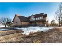 Inviting two-story home with a welcoming porch and mature trees on a spacious lot, perfect for serene living at 1120 Antelope W Dr, Bennett, CO 80102