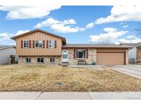 Charming two-story home with a well-manicured lawn and a welcoming front porch at 16652 E Gunnison Pl, Aurora, CO 80017