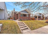 Charming brick home with a cozy front porch and well-manicured lawn at 745 Garfield St, Denver, CO 80206