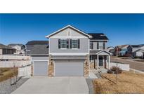 Two-story house with gray siding, two-car garage, and a landscaped yard at 5471 Scenic Ave, Firestone, CO 80504
