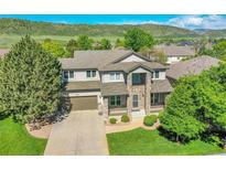 Beautiful two-story home boasts manicured lawn, lush landscaping and a stone facade entry at 8427 S Parfet Ct, Littleton, CO 80127