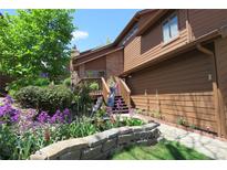 Charming brown home with well-manicured flowerbeds and stone retaining wall leading to front steps at 283 Yank Ct, Lakewood, CO 80228