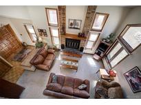 Bright living room featuring a brick fireplace and multiple windows for natural light at 283 Yank Ct, Lakewood, CO 80228