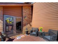 Charming patio with wicker chairs, flower accents, and a welcoming entrance at 283 Yank Ct, Lakewood, CO 80228