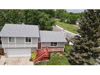 Split-level home features brick accents, and an elevated red stairway to the front door at 8595 Field Ct, Arvada, CO 80005