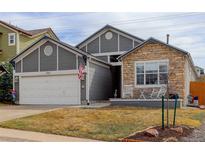Charming single-Gathering home featuring stone accents, gray siding, and a well-manicured lawn at 11081 Cannonade Dr, Parker, CO 80138