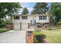 Charming two-story home with a well-manicured lawn and stone accents at 10473 W Arkansas Dr, Lakewood, CO 80232