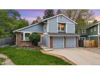 Charming two-story home with blue siding, brick accents, and a well-manicured lawn at 8940 W 80Th Dr, Arvada, CO 80005