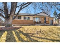 Charming brick home featuring a well-maintained lawn and covered front porch at 6882 S Downing E Cir, Centennial, CO 80122