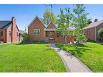 Charming brick home with a well-manicured lawn and inviting walkway on a sunny day at 1434 Clermont St, Denver, CO 80220