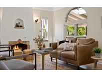 Cozy living room with a fireplace, comfortable seating, and a large window at 1434 Clermont St, Denver, CO 80220