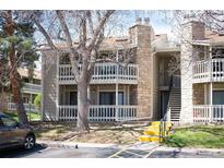 Two-story condo featuring balconies, stone accents, and stairs leading to upper units at 8225 Fairmount Dr # 10-204, Denver, CO 80247