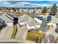 Expansive aerial view of a home with solar panels, a charming flag, and mature trees in a friendly neighborhood at 2595 W 107Th Pl, Westminster, CO 80234