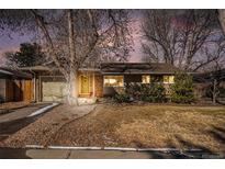 Charming single-story home with an attached garage and beautifully maintained front yard at sunset at 3083 S Xanthia St, Denver, CO 80231