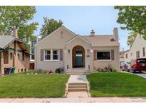 Charming stucco home featuring a quaint arched entryway and a well-maintained lawn at 848 Harrison St, Denver, CO 80206